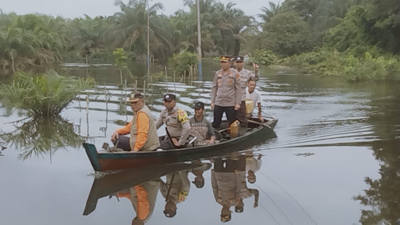 Banjir Meluas, Polsek Rengat Barat Gunakan Sampan saat Cooling System Pemilu Damai