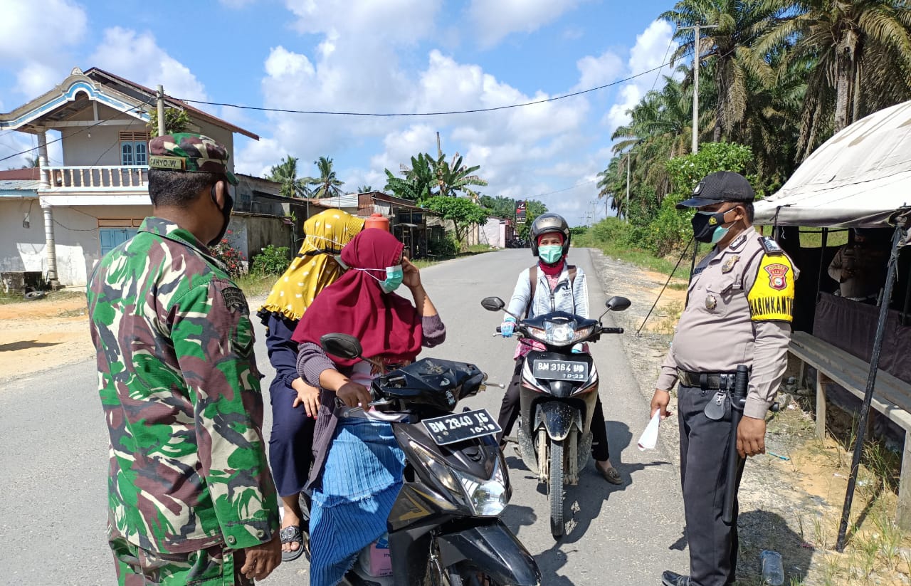 Stop Pengguna Jalan, Polsek Kerumutan bersama Babinsa Bagikan Masker Gratis