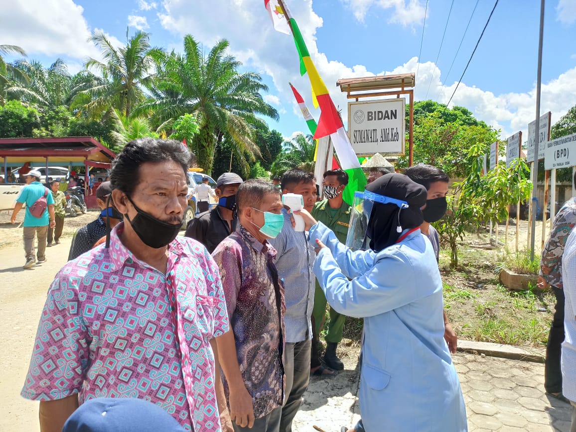 Tim Kukerta Relawan Covid-19 UNRI 2020 Bantu Penerapan Protokol Kesehatan Saat Pembagian BLT di Desa Gondai Kecamatan Langgam