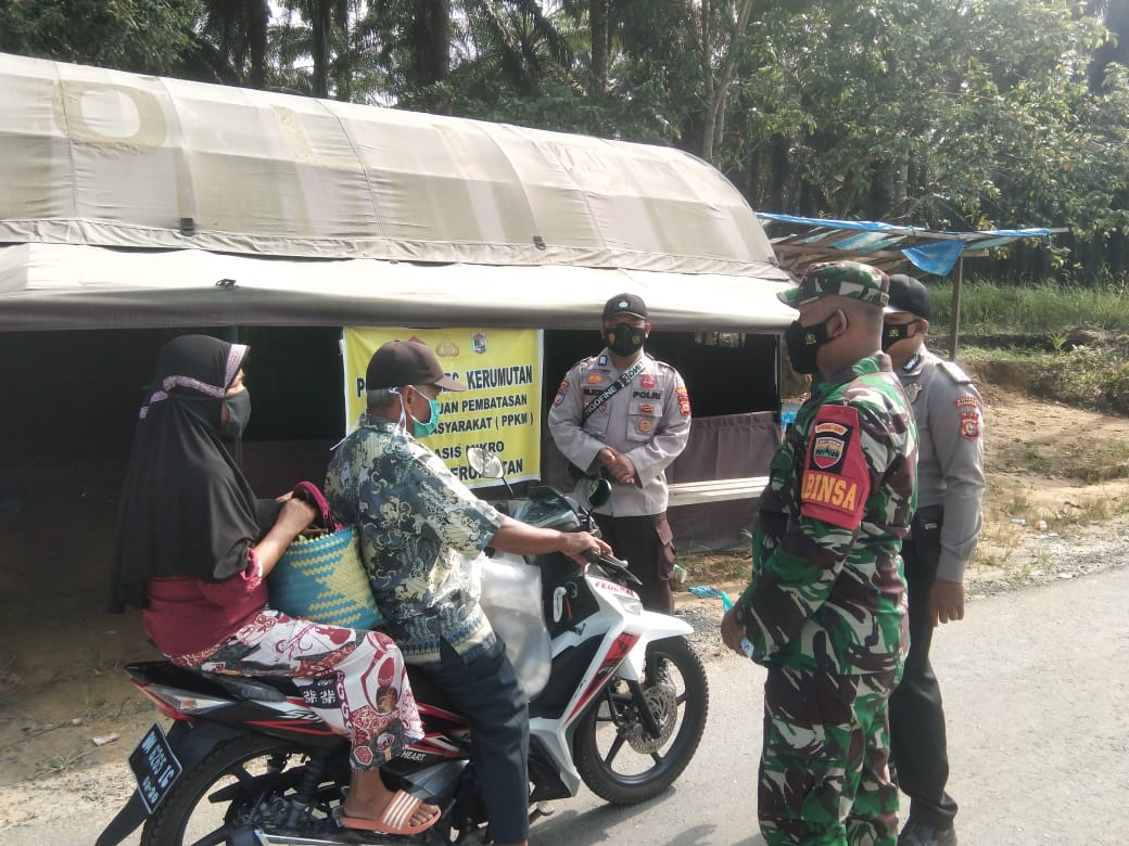 Bhabinkamtibmas Polsek Kerumutan Himbau Warga dan Bagikan masker di Pos PPKM