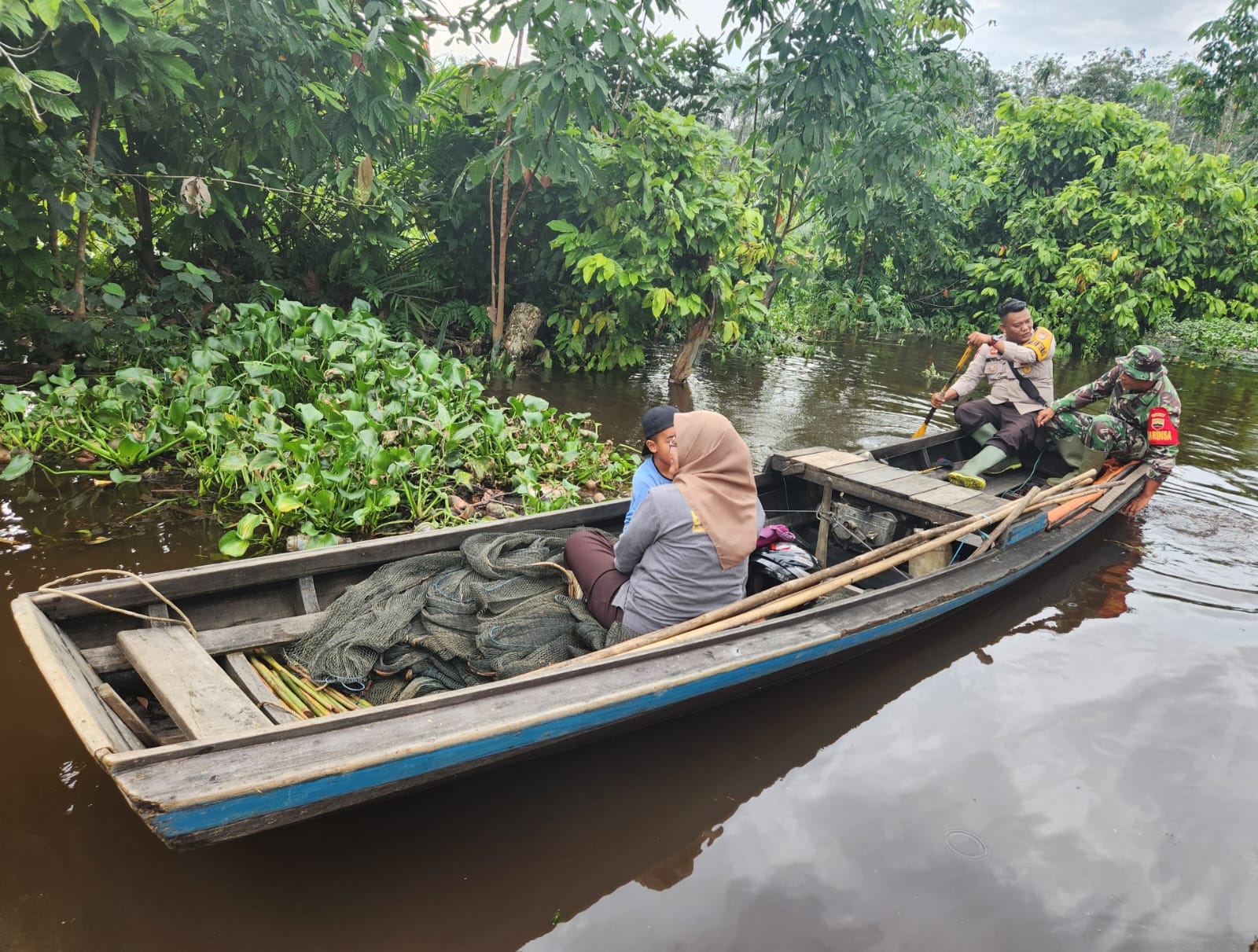 Antar Warga Pulang dengan Perahu Kayu, Babinkamtibmas Kempas dan Babinsa Kompak di Inhil