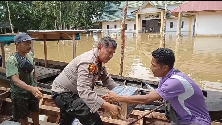 Kapolsek Siak Hulu Naik Perahu Bantu Korban Banjir Sambil Sosialisasi Pemilu
