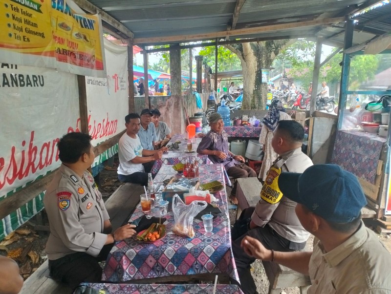 Bhabinkamtibmas Polsek Singingi Edukasi Pengunjung Pasar tentang Pilkada Damai sambil Makan Sate