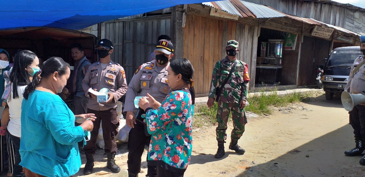 Datangi Pasar Tradisional Kapolsek Kerumutan Bagikan Masker Gratis Kepada Warga