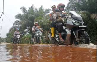 Bawa Pesan Pemilu Damai, Kapolsek Kuala Cenaku Terobos Banjir Sambangi Warga