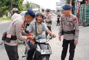Rayakan HUT RI ke-80, Brimob Polda Riau Bagikan Bendera Merah Putih ke Masyarakat