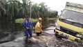 Dua Perwira Bantu Tarik Mobil Box Terperosok di Lokasi Banjir Pelalawan